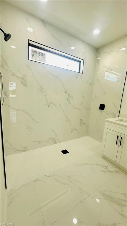 Full bath featuring vanity, a marble finish shower, recessed lighting, and stone wall