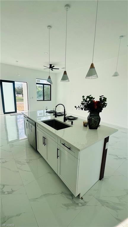 Kitchen with pendant lighting, a kitchen island with sink, light stone counters, white cabinetry, and dishwasher