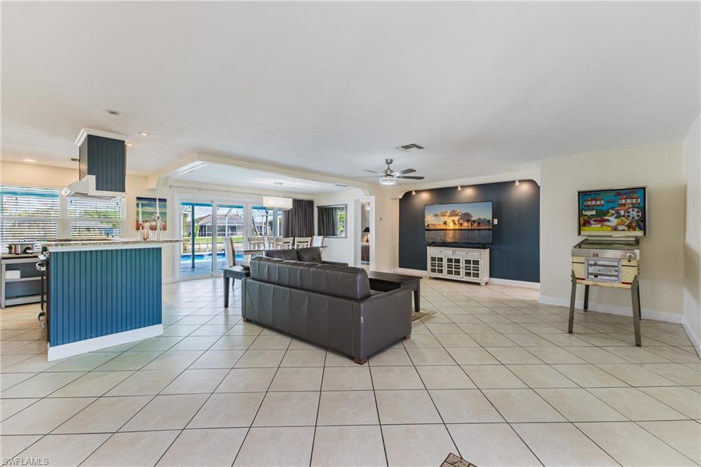 Living room with a ceiling fan, light tile patterned floors, and recessed lighting