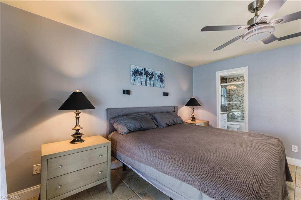 Bedroom with ensuite bathroom, a ceiling fan, and light tile patterned floors