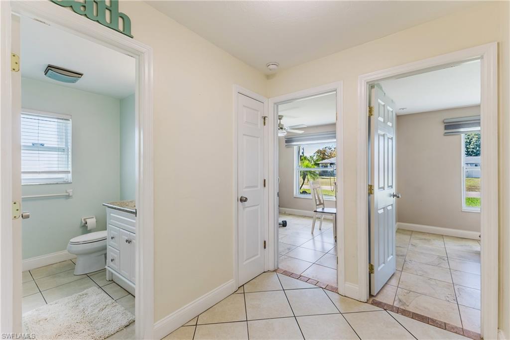 Corridor featuring healthy amount of natural light and light tile patterned flooring