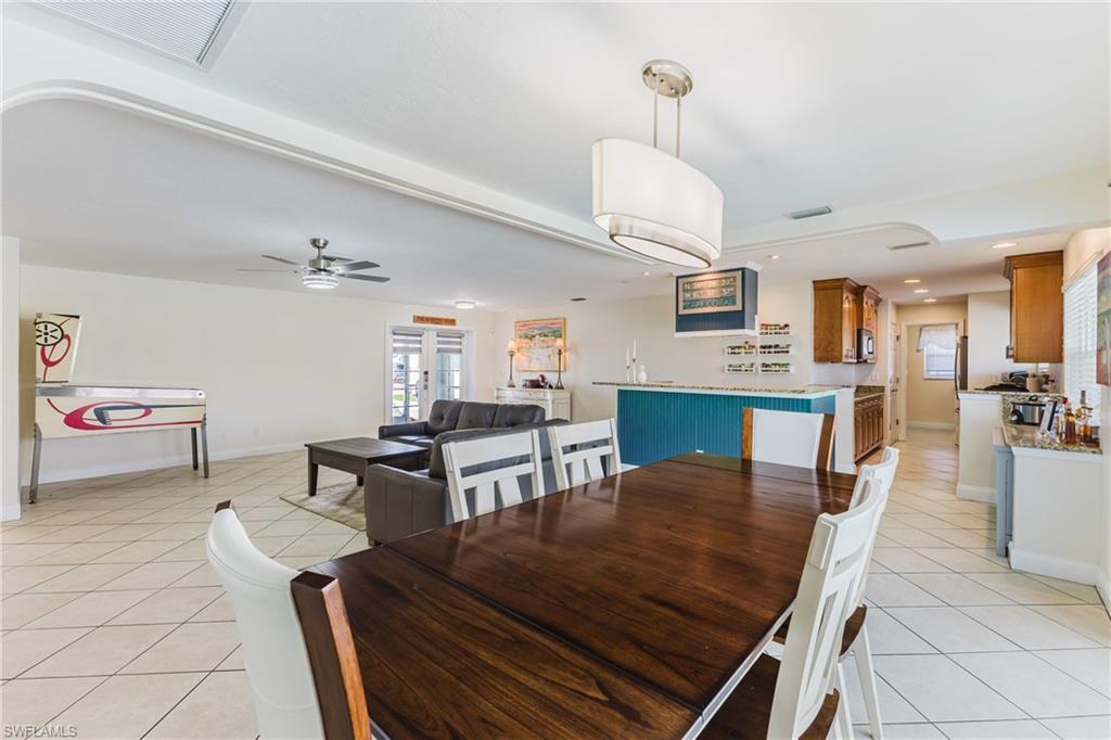 Dining area featuring light tile patterned floors, a ceiling fan, and recessed lighting