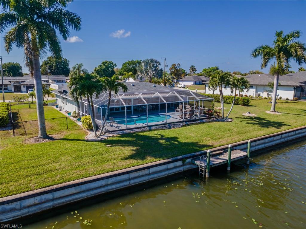 Dock featuring a lawn, a lanai, a water view, a patio, and a sunroom