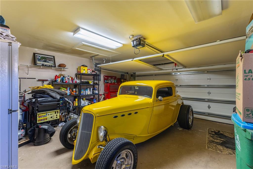 Garage with freestanding refrigerator and a garage door opener