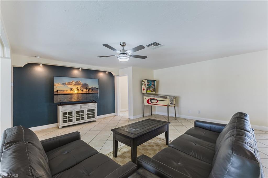 Living area with ceiling fan and light tile patterned flooring