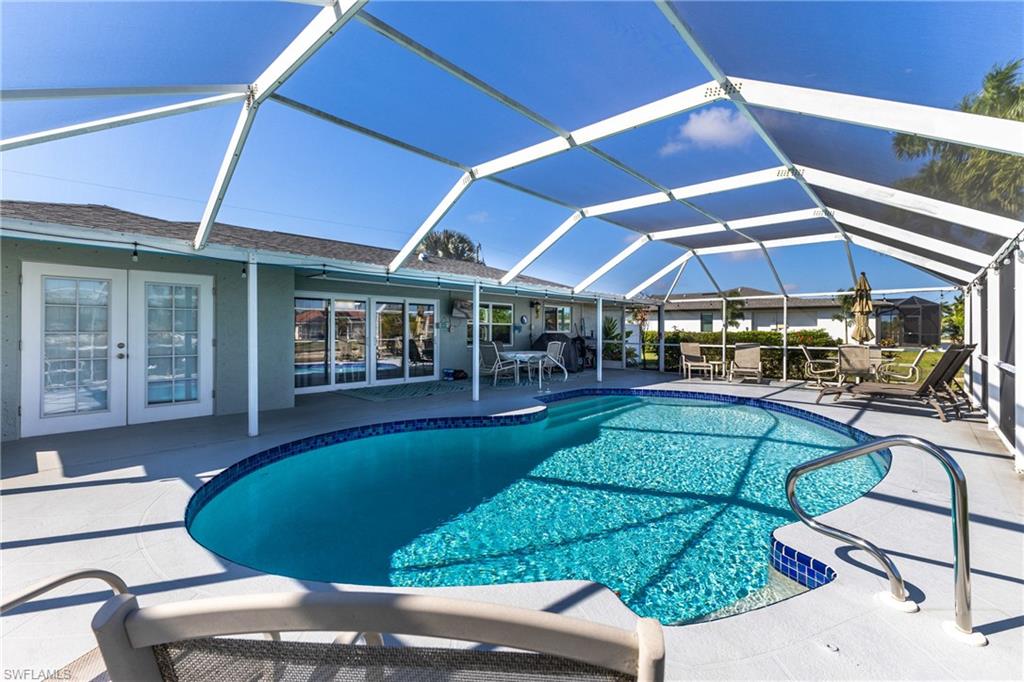 Swimming pool with a sunroom, a patio, french doors, and a lanai