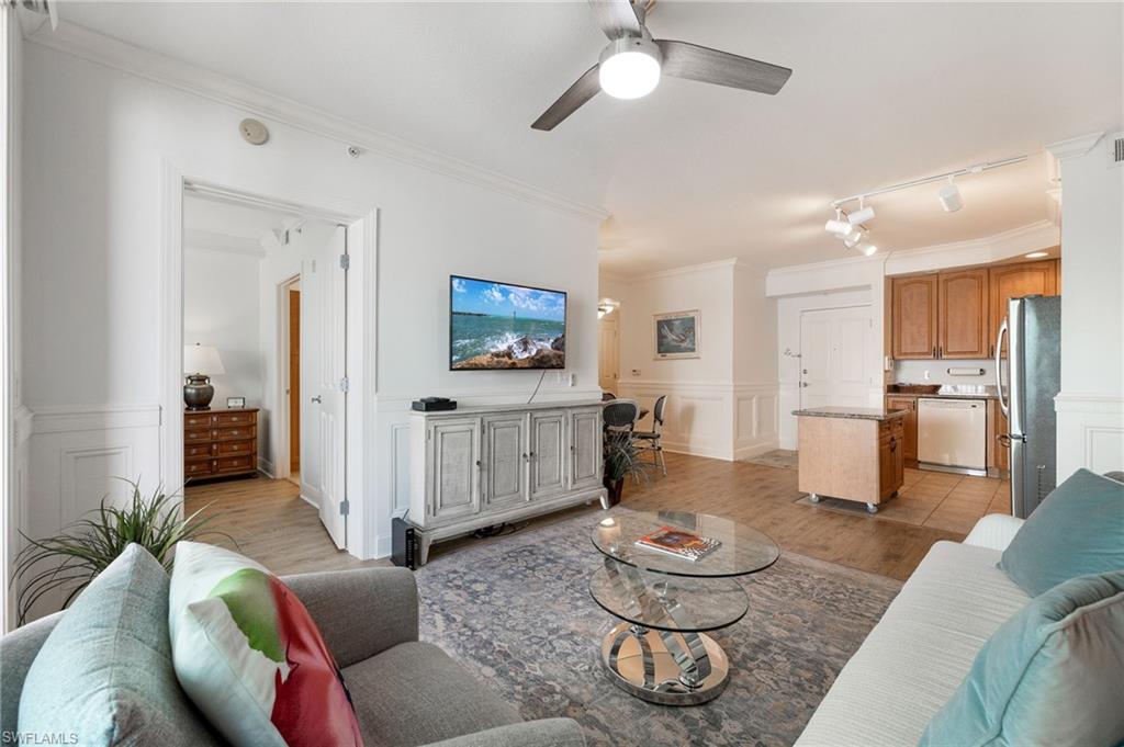 Living room featuring crown molding, track lighting, ceiling fan, and light hardwood / wood-style floors