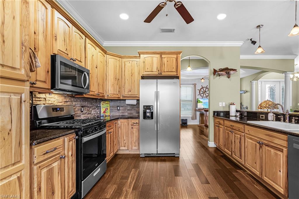 new stainless-steel appliances, propane stove/cooktop, granite countertops, breakfast bar, and beautiful solid wood cabinets
