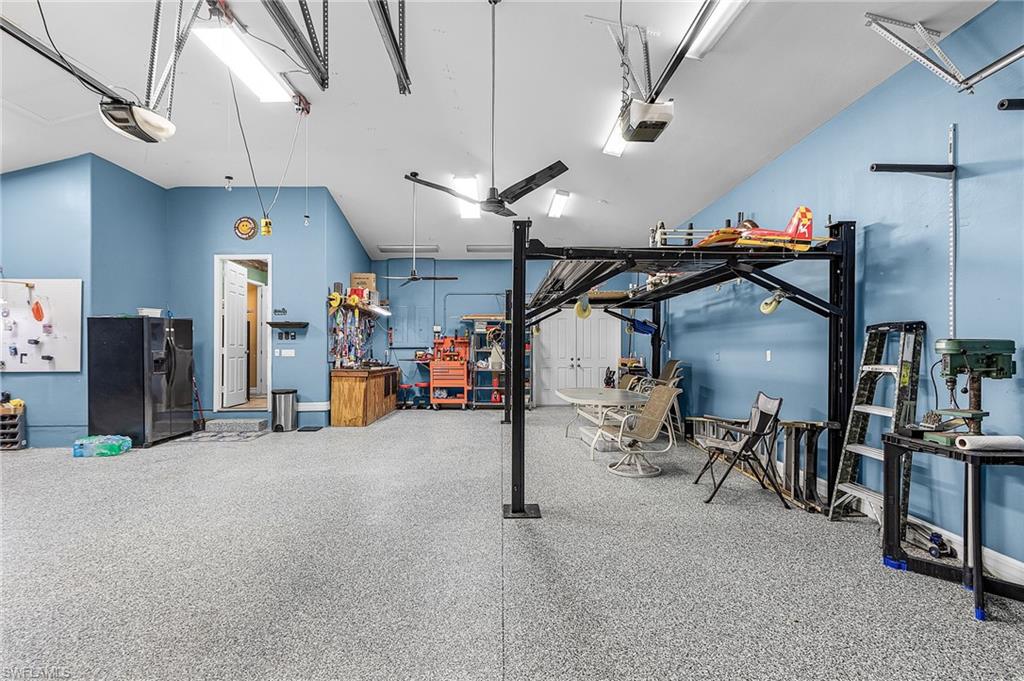 a massive 1,242 sq ft, 5 PLUS car garage, with 3 bay garage doors, comes with a 8,300 lb car lift, epoxy floor, 14’ high ceilings, shop lighting, wired for whole house generator, garage refrigerator, with double exit doors to a fenced back yard
