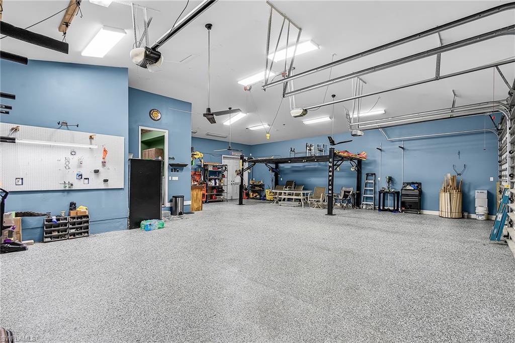 a massive 1,242 sq ft, 5 PLUS car garage, with 3 bay garage doors, comes with a 8,300 lb car lift, epoxy floor, 14’ high ceilings, shop lighting, wired for whole house generator, garage refrigerator, with double exit doors to a fenced back yard