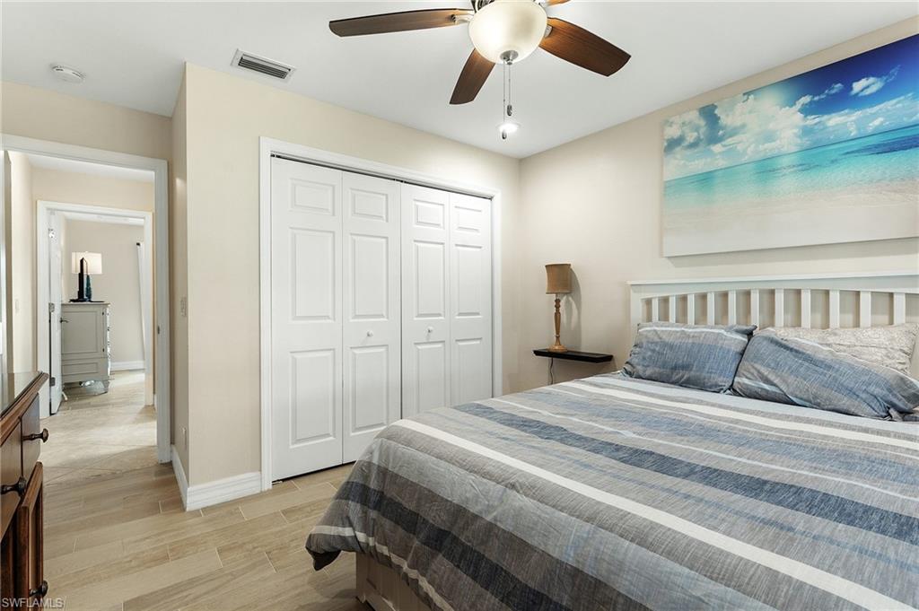 Bedroom featuring wood tiled floors, ceiling fan, and a closet