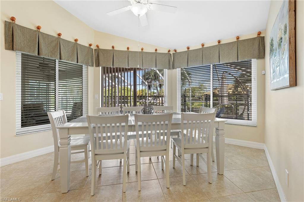Dining room with light tile patterned flooring, lofted ceiling, and a ceiling fan