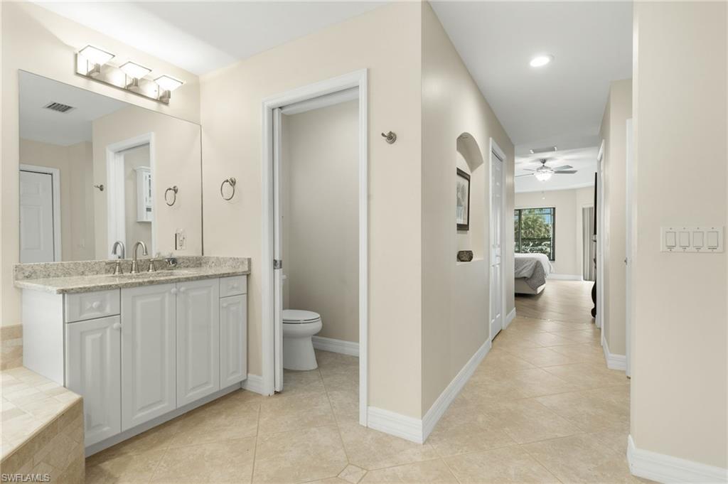 Full bath featuring light tile patterned flooring, vanity, connected bathroom, ceiling fan, and recessed lighting