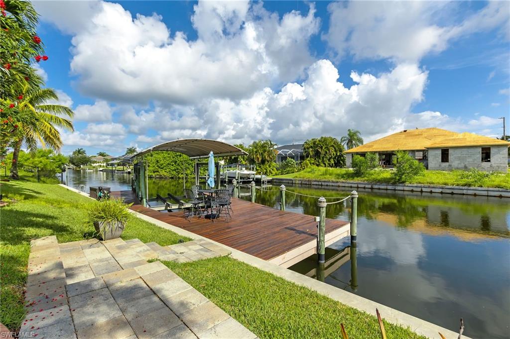 Dock area with lift and a water view and a yard