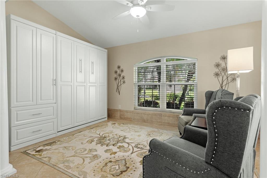 Sitting room with light tile patterned flooring, lofted ceiling, and a ceiling fan