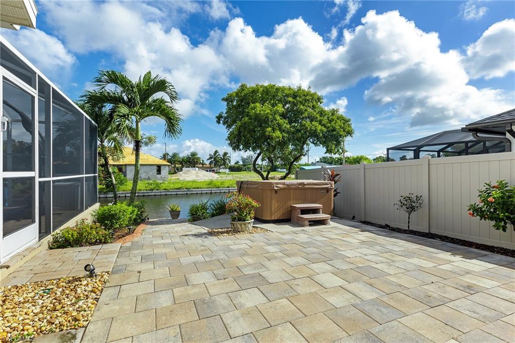 View of patio / terrace featuring a hot tub, a lanai
