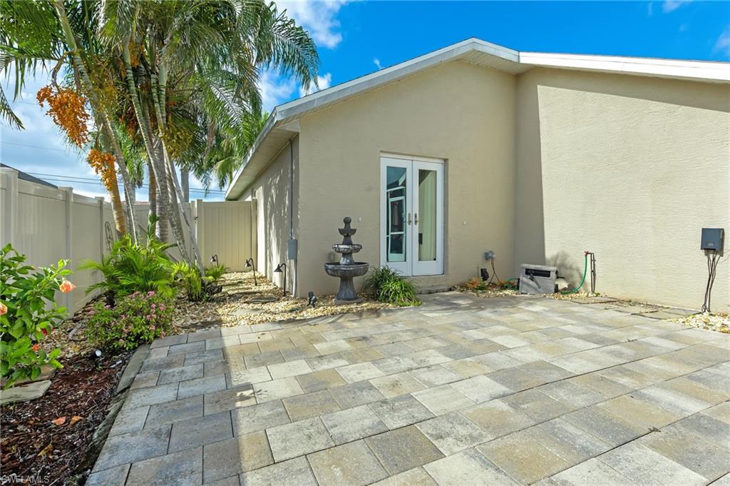Back of house with french doors, stucco siding, and a fenced backyard