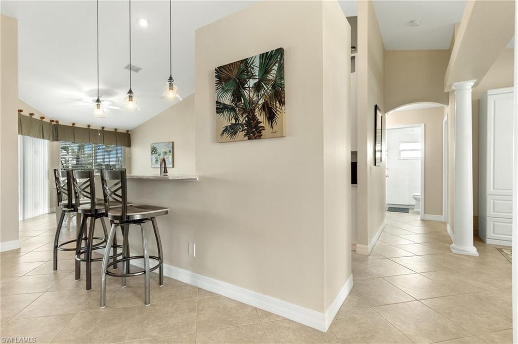 Hallway featuring light tile patterned floors and arched walkways