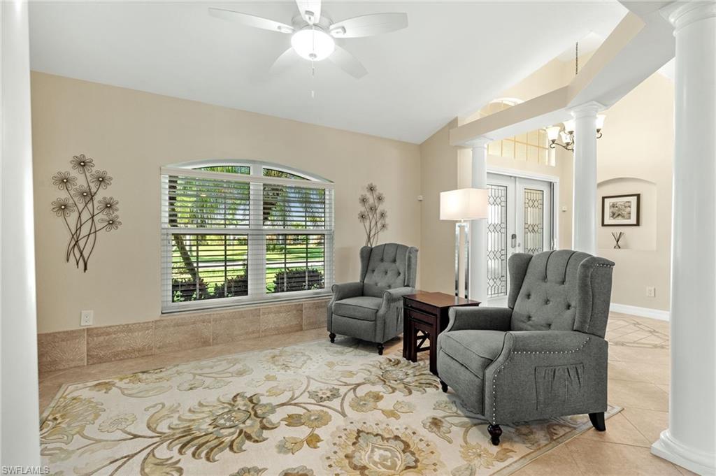 Sitting room featuring decorative columns, tile patterned floors, a ceiling fan, and french doors