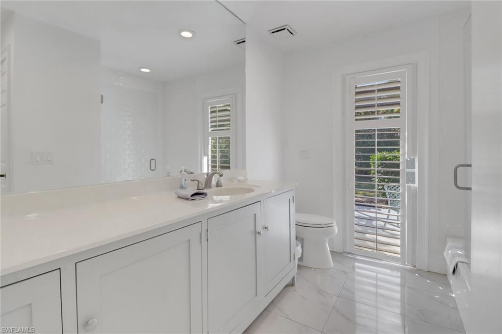 Guest Bathroom features a newer tub and shower combo with subway tile seamless glass shower door, newer solid wood cabinets, water closet