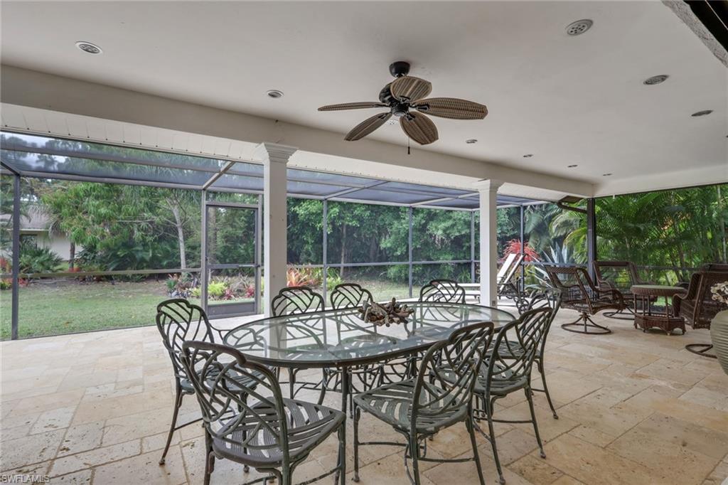 View of patio enclosure, outdoor dining area, a ceiling fan, recessed lighting, travertine tiled flooring