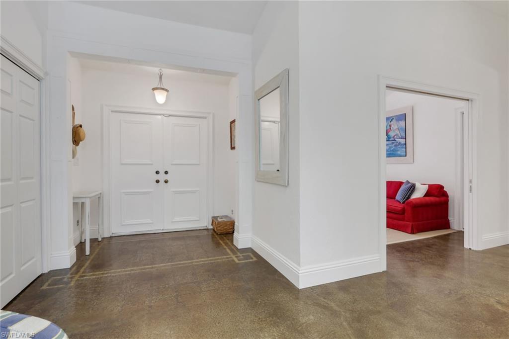 Foyer 7-inch baseboards and polished concrete floors, pocket doors open to third bedroom/den
