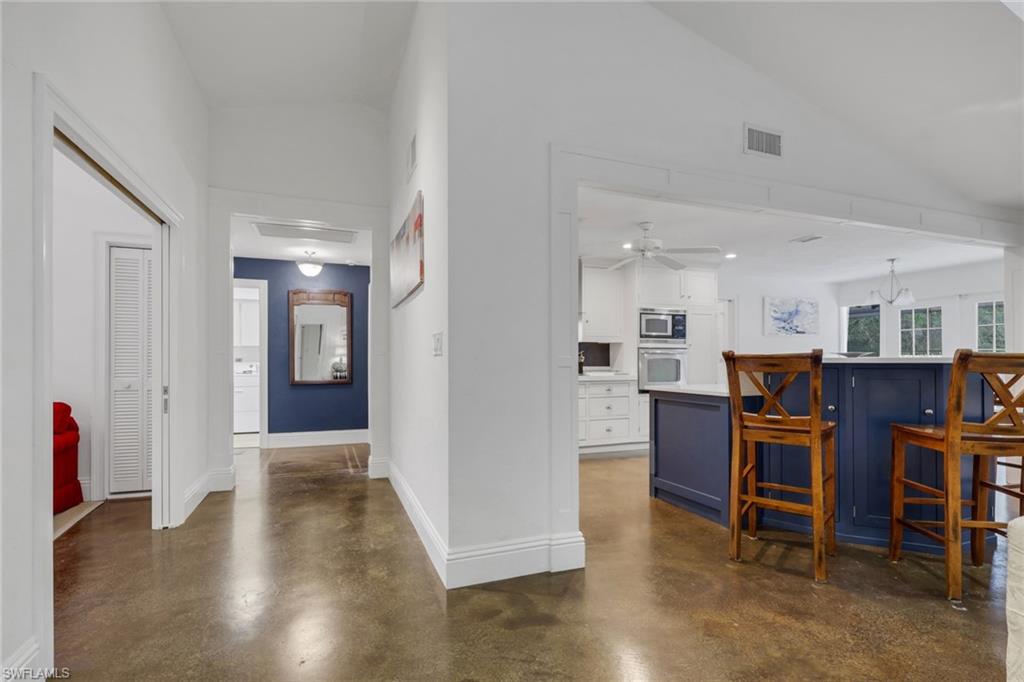 Hallway featuring concrete floors and vaulted ceiling