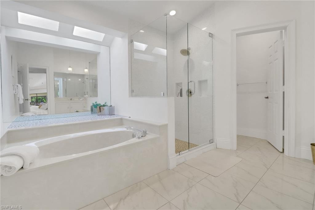 Spacious Primary Bathroom with wonderful soaking tub and custom walk-in shower, sky lights recessed lightingprivate water closet