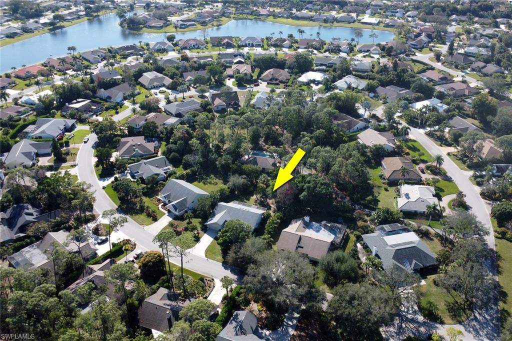 Woodland's arrow is pointing to 2293 Royal Lane with the Woodlands Pool in the background surround by lush tropical folige of presver area