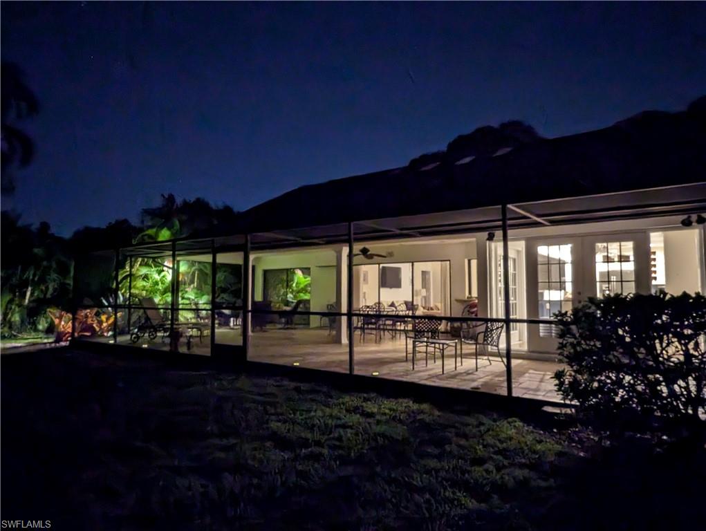 Back of house at twilight featuring a patio area and ceiling fan