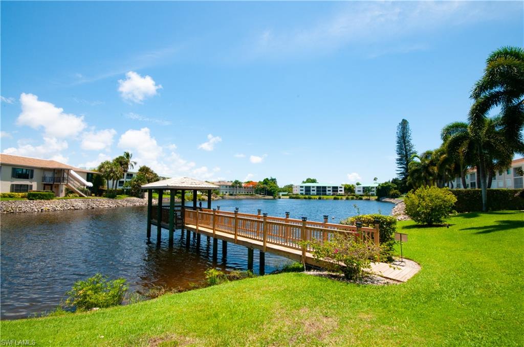 Dock area featuring a water view and a lawn