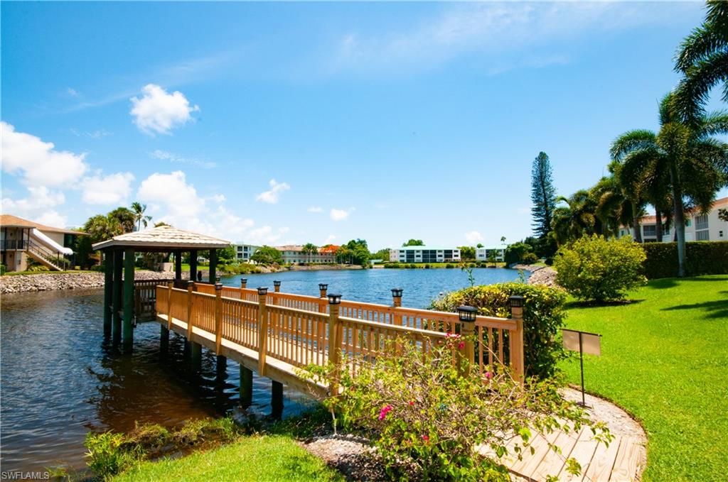 Dock area with a water view, a lawn, and a gazebo