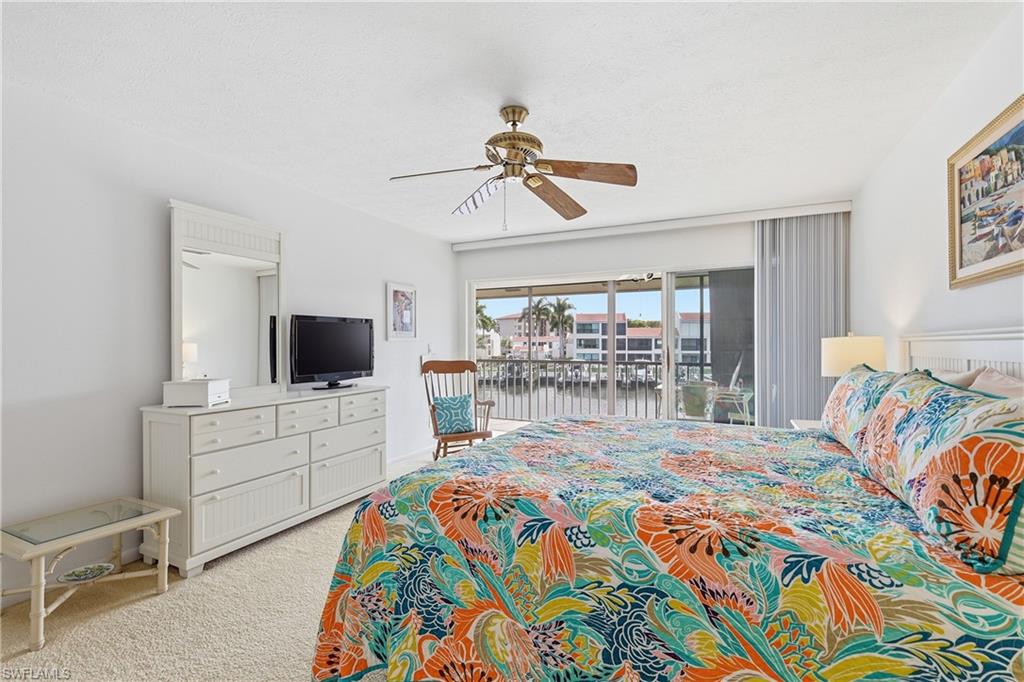 Bedroom with access to outside, a ceiling fan, and light colored carpet