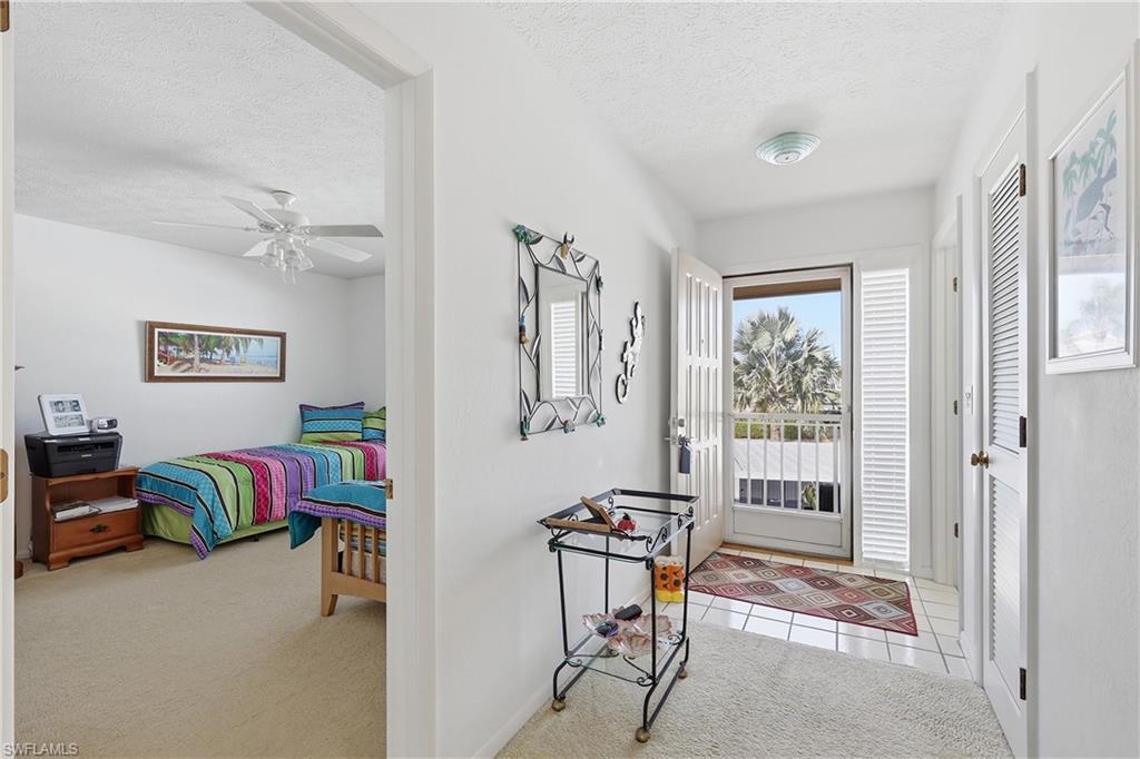 Entryway with light carpet, a textured ceiling, and ceiling fan