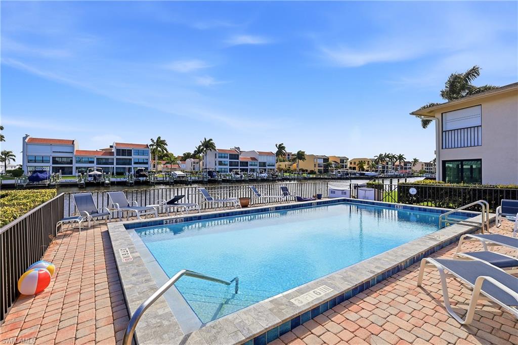 Community pool with a patio area, a residential view, and a water view