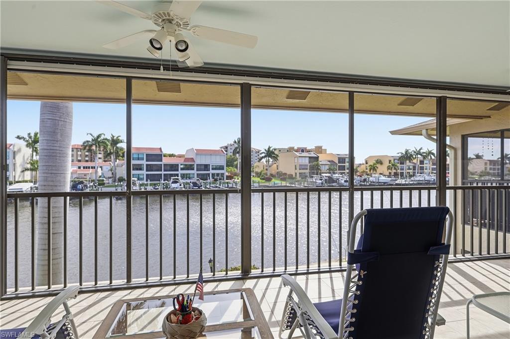 Sunroom featuring a water view and a residential view