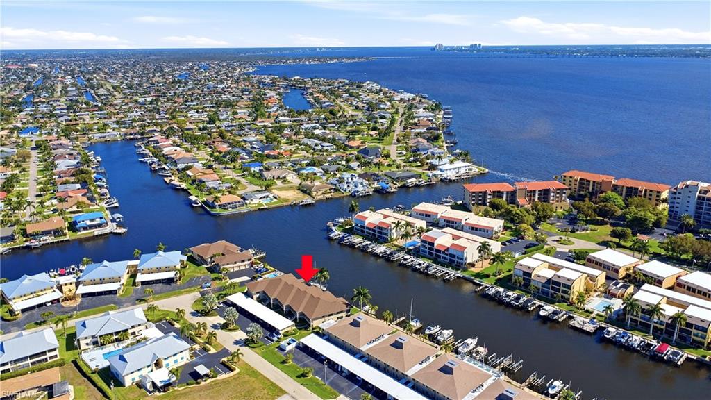 Aerial view of property and surrounding area with a large body of water and nearby suburban area