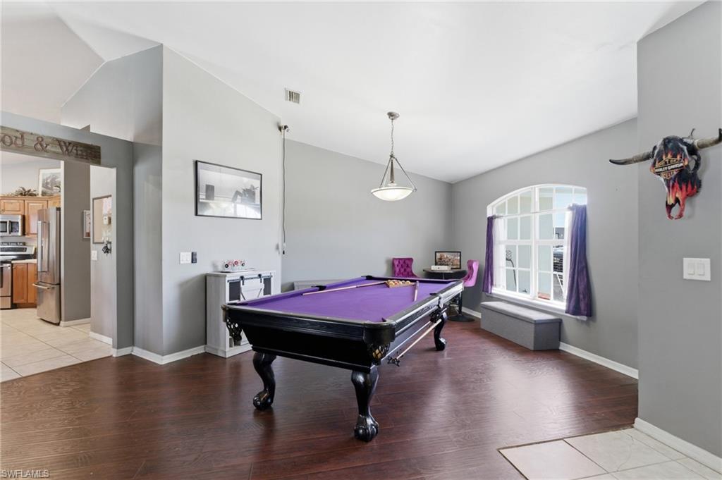 Rec room with lofted ceiling, light wood-style floors, and billiards