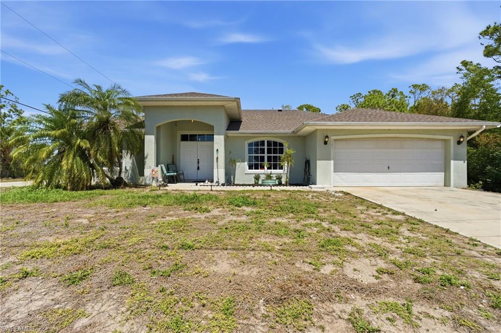 View of front of home featuring a garage, stucco siding, concrete driveway, and roof with shingles