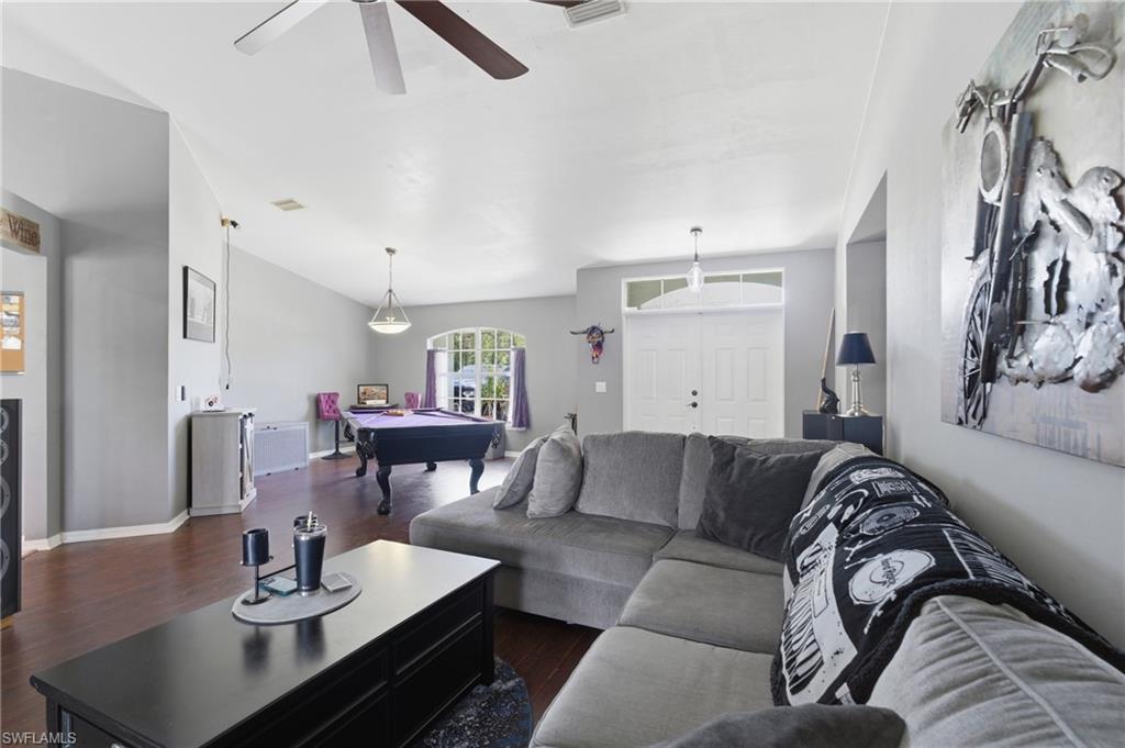 Living room featuring billiards, dark wood-style floors, and a ceiling fan