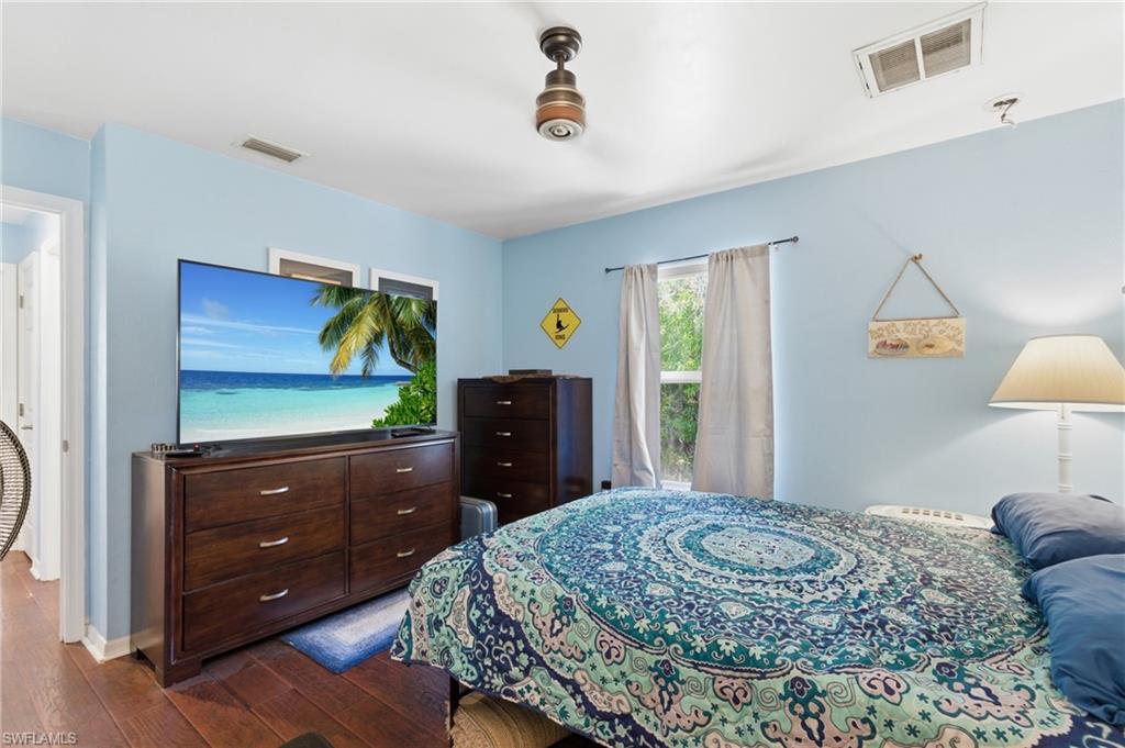 Bedroom with dark wood finished floors and baseboards