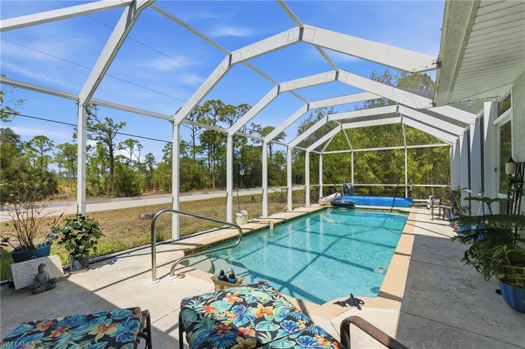 Swimming pool with a lanai, a sunroom, and a patio