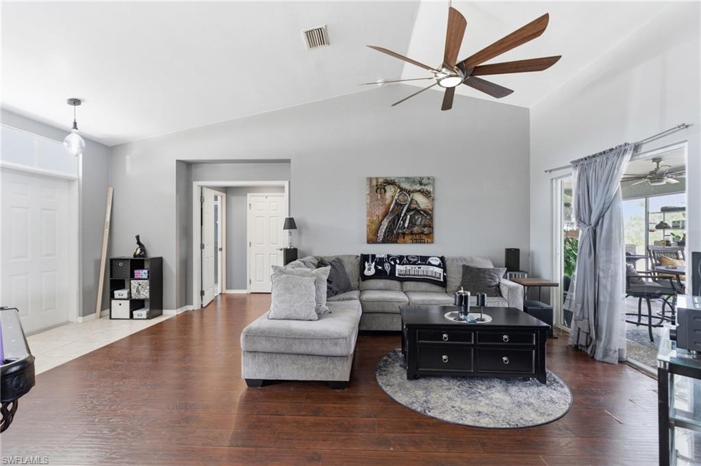 Living area with ceiling fan, lofted ceiling, and wood finished floors