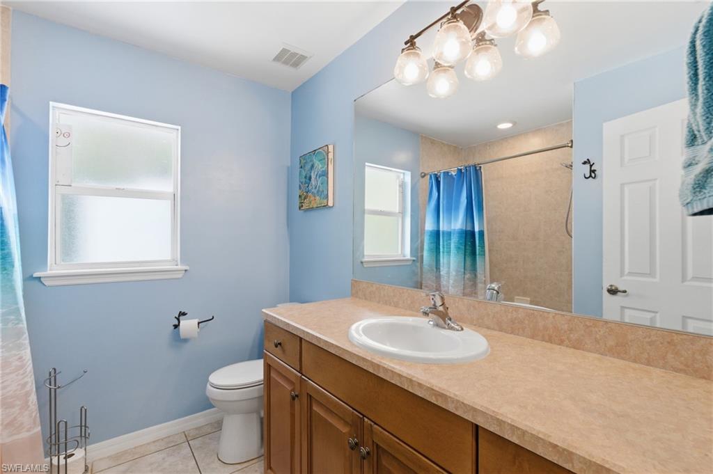 Full bath featuring vanity, light tile patterned floors, and a shower with shower curtain