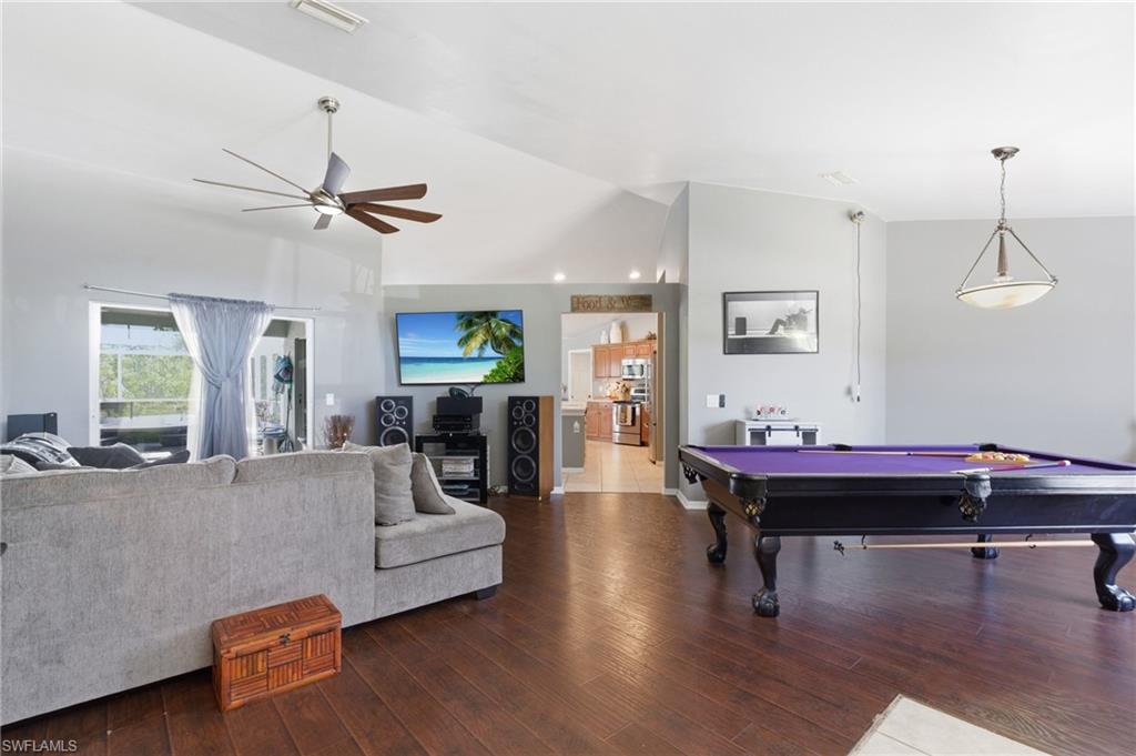 Game room with billiards, wood finished floors, ceiling fan, and lofted ceiling