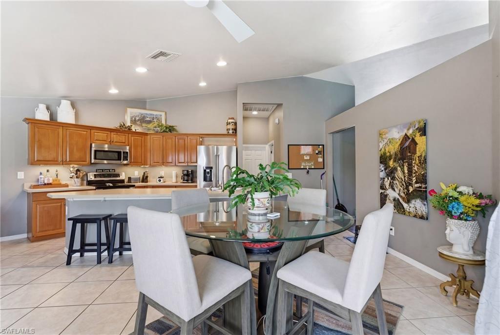 Dining space featuring light tile patterned floors, vaulted ceiling, and a skylight
