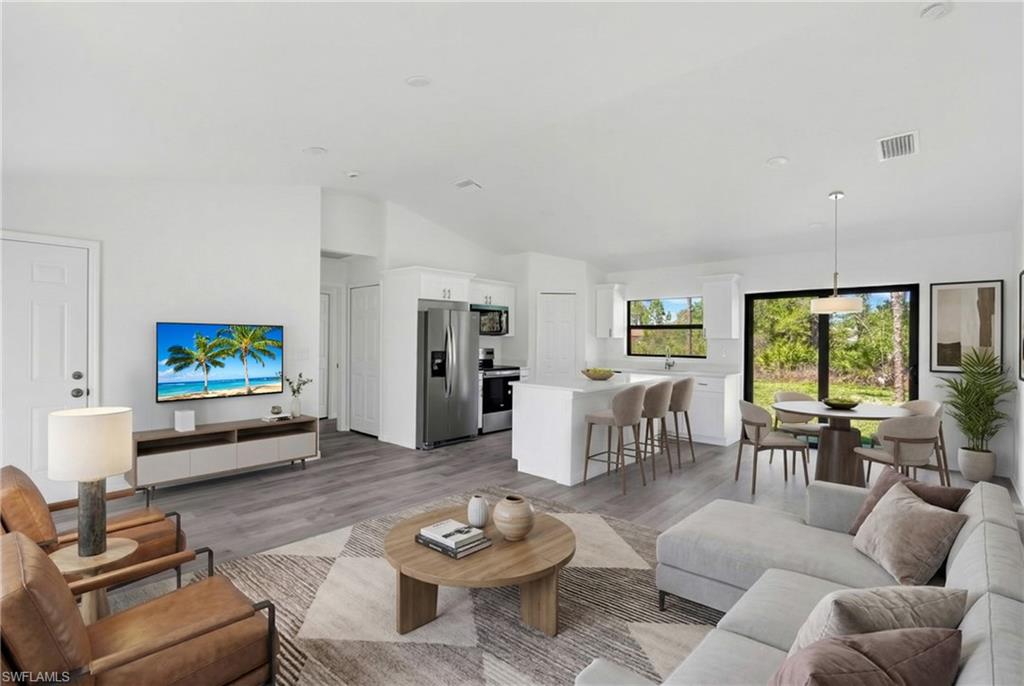 Living room with light wood finished floors and lofted ceiling