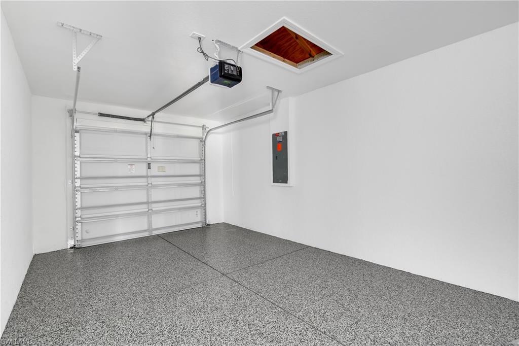 Garage featuring electric panel and a garage door opener
