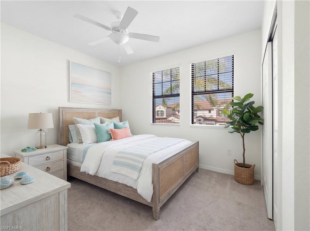 Bedroom with light carpet and a ceiling fan