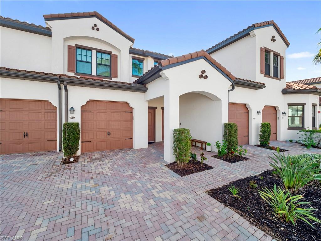 Mediterranean / spanish home featuring stucco siding, a tile roof, decorative driveway, and a garage